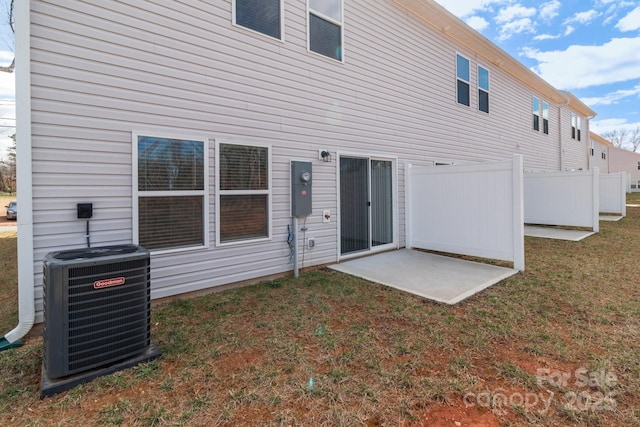 back of property featuring central AC, a yard, and fence