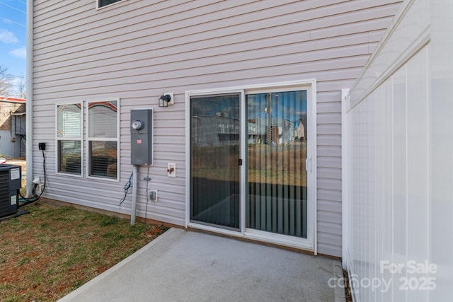 entrance to property featuring a patio area and central air condition unit