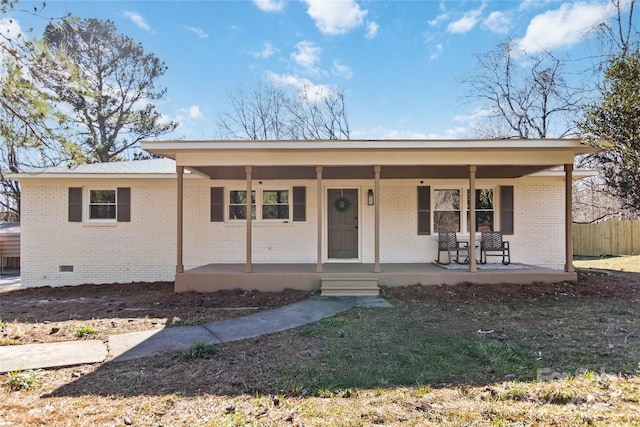 ranch-style home with a porch, crawl space, brick siding, and fence