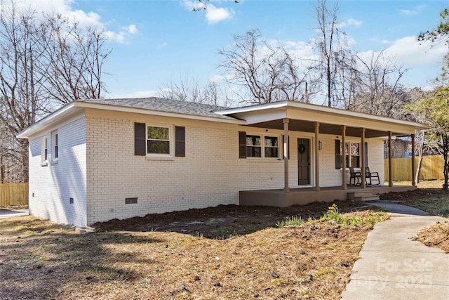 single story home with covered porch, brick siding, crawl space, and fence