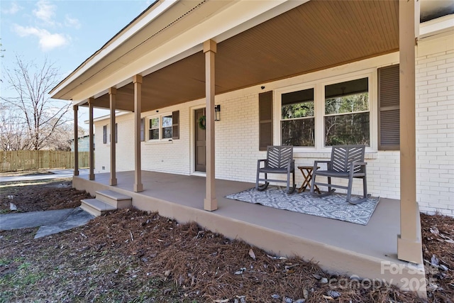 view of patio with a porch and fence