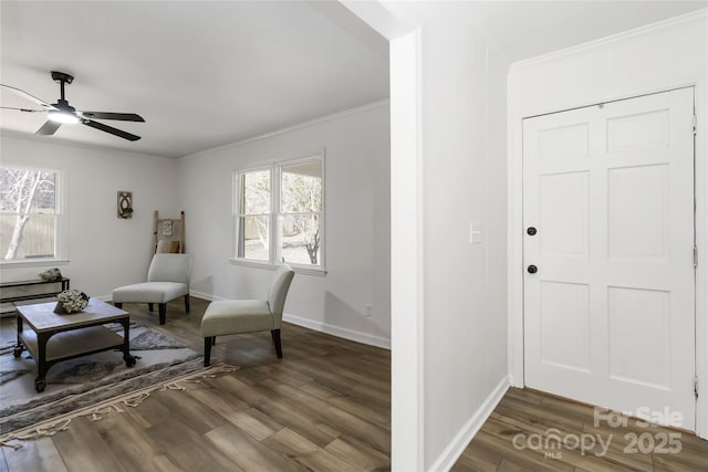 living area featuring crown molding, wood finished floors, a ceiling fan, and baseboards