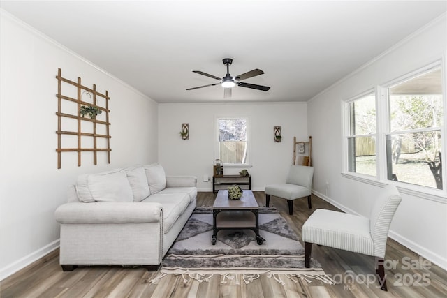 living room with baseboards, ornamental molding, ceiling fan, and wood finished floors