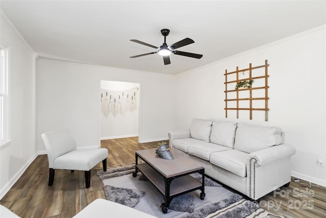 living area featuring crown molding, baseboards, ceiling fan, and wood finished floors