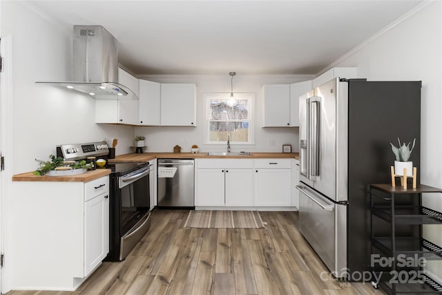 kitchen with stainless steel appliances, island exhaust hood, wooden counters, and a sink