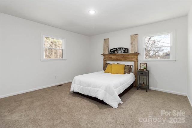 carpeted bedroom with multiple windows, visible vents, and baseboards