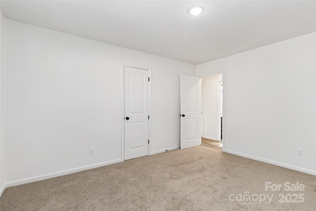 unfurnished bedroom featuring light carpet and baseboards