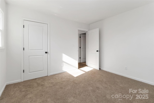 unfurnished bedroom with carpet floors and baseboards