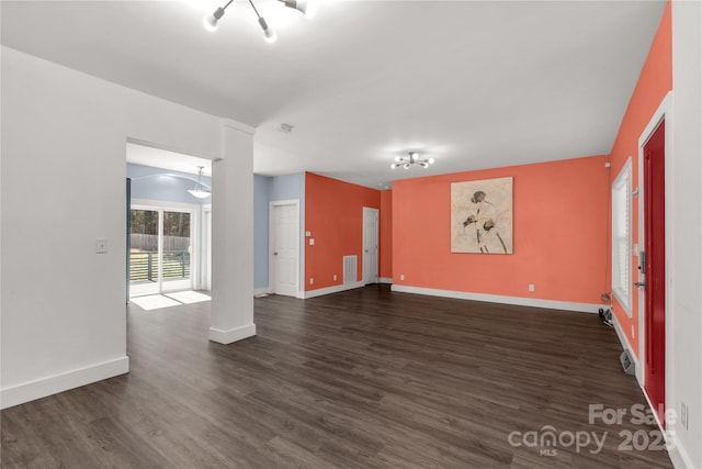 unfurnished living room with dark wood-style floors, visible vents, and baseboards