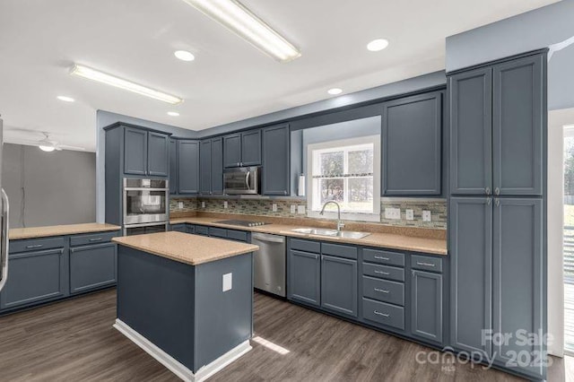 kitchen featuring dark wood-style floors, stainless steel appliances, tasteful backsplash, and a sink