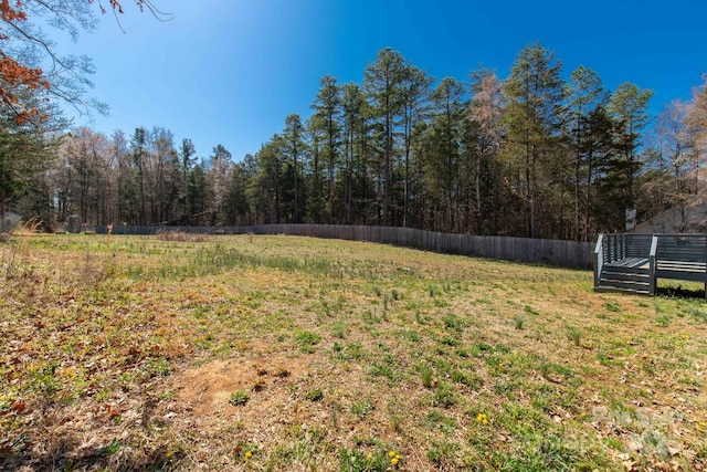 view of yard featuring fence and a wooded view