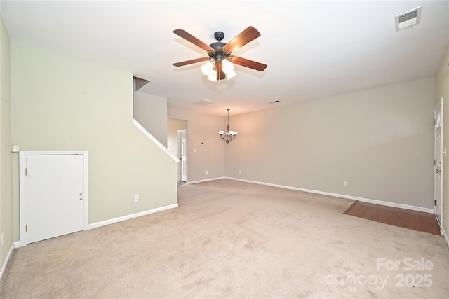 spare room with visible vents, light carpet, baseboards, and ceiling fan with notable chandelier