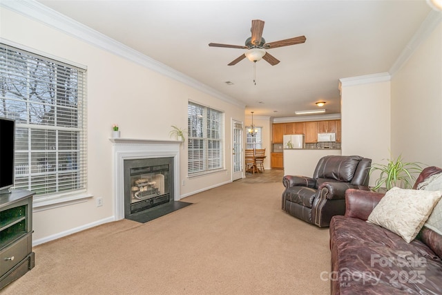 living area featuring light colored carpet, crown molding, and baseboards