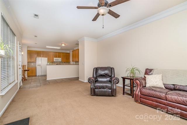 living room with crown molding, light colored carpet, visible vents, and baseboards