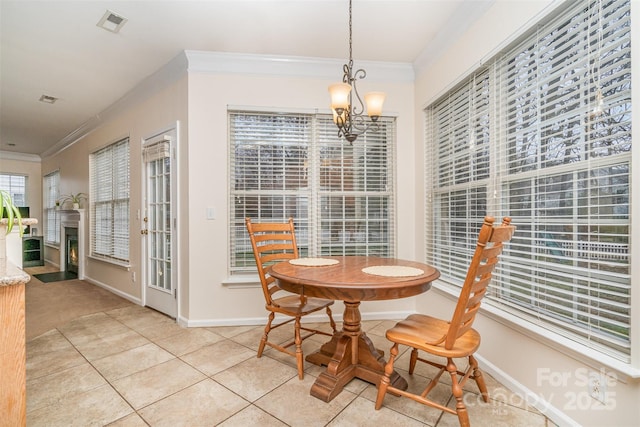 dining room with a fireplace with flush hearth, crown molding, and baseboards