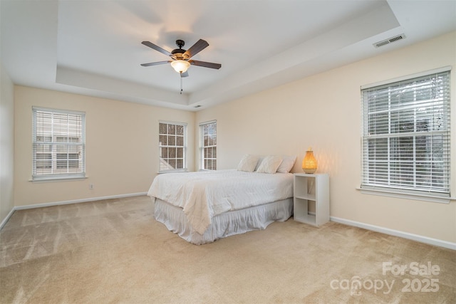 bedroom with visible vents, a raised ceiling, baseboards, and carpet flooring