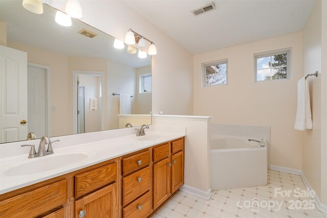 bathroom featuring tile patterned floors, visible vents, and a sink