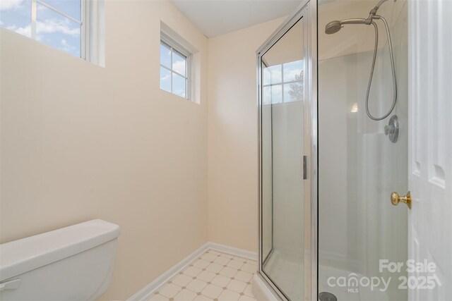 full bathroom with tile patterned floors, baseboards, toilet, and a stall shower