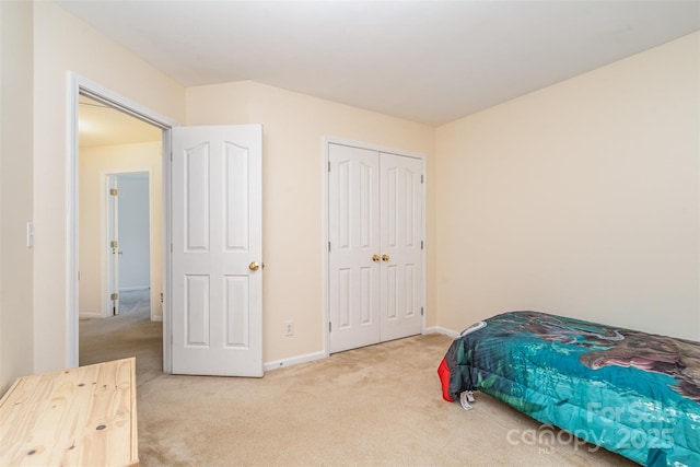 carpeted bedroom featuring a closet and baseboards