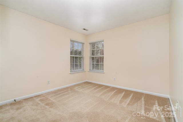 carpeted empty room with baseboards and visible vents