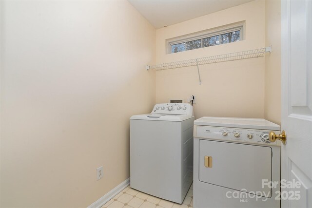 laundry room with laundry area, light floors, baseboards, and washing machine and clothes dryer