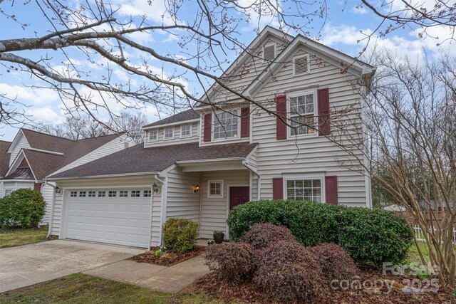 traditional-style home with driveway, a shingled roof, and a garage