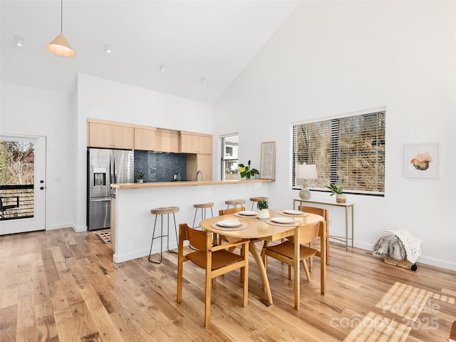 433 W Haywood St, Asheville, NC 28801 - dining space with light wood finished floors, a wealth of natural light, baseboards, and high vaulted ceiling