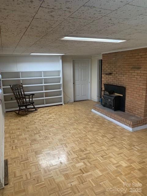 below grade area featuring a wood stove and parquet flooring