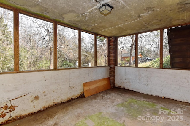 unfurnished sunroom featuring concrete flooring