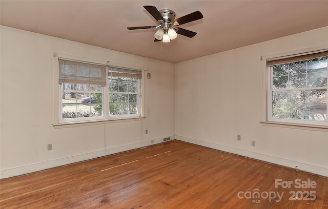 spare room with ceiling fan, baseboards, and hardwood / wood-style floors