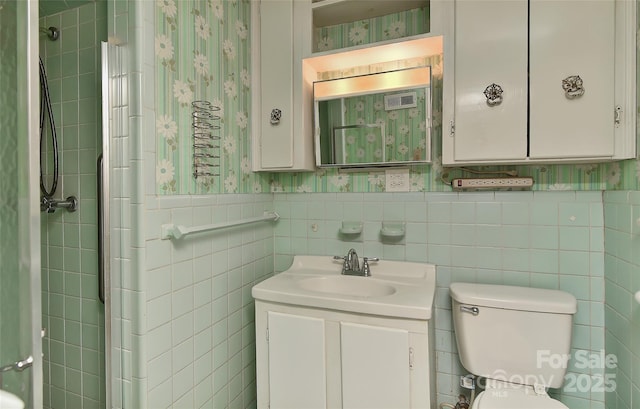 full bathroom with vanity, toilet, wainscoting, and wallpapered walls