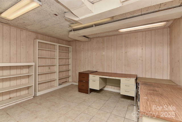 unfurnished office with light tile patterned floors and wood walls