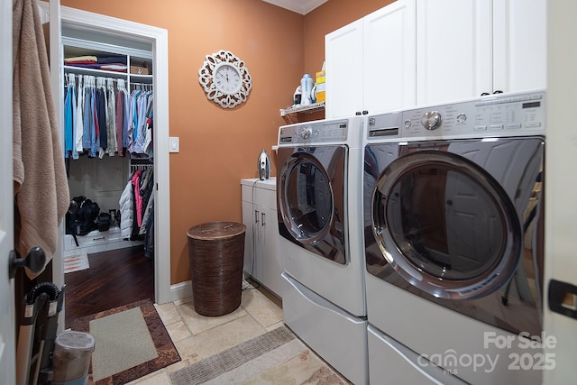 clothes washing area featuring washer and dryer, baseboards, cabinet space, and stone tile floors