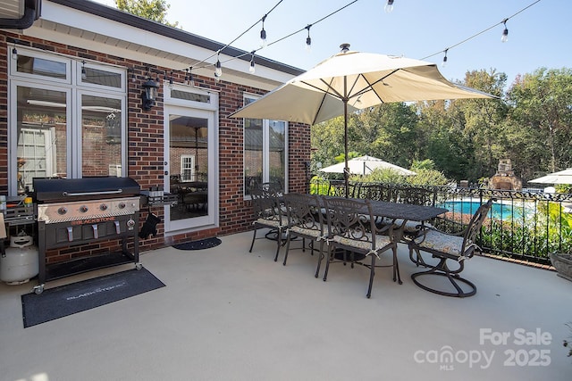 view of patio / terrace with a grill, an outdoor pool, and outdoor dining space