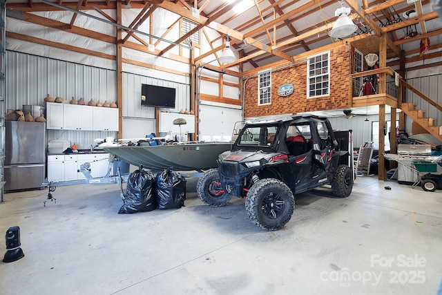 garage featuring metal wall and freestanding refrigerator