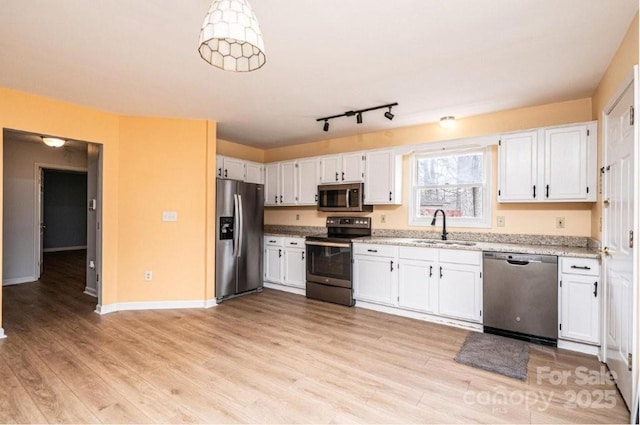 kitchen with stainless steel appliances, light wood-type flooring, a sink, and white cabinets