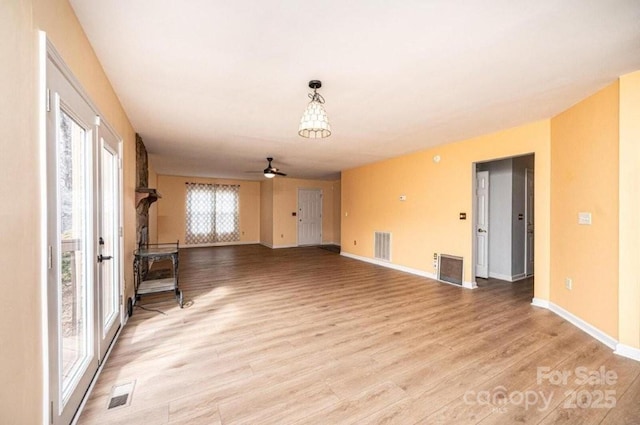 interior space featuring light wood-style floors, visible vents, and baseboards