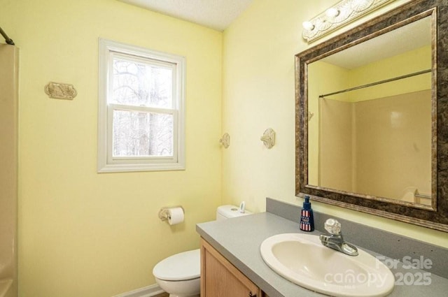 bathroom featuring vanity, toilet, and walk in shower