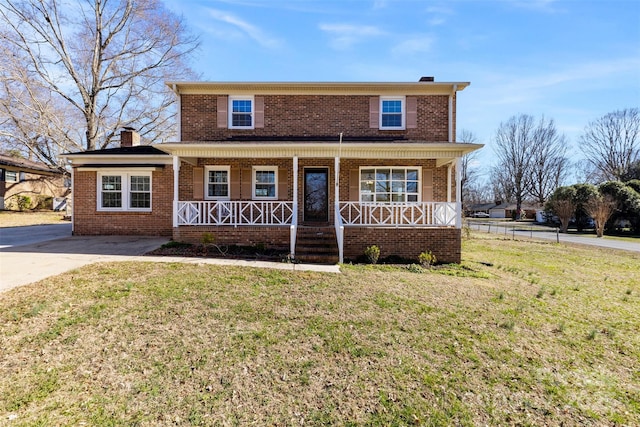 traditional-style house with a porch, a front yard, brick siding, and a chimney