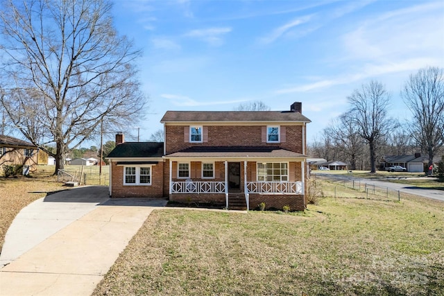 view of front of home featuring a porch, a front lawn, a chimney, and brick siding