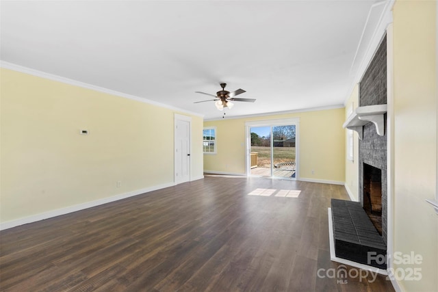 unfurnished living room with baseboards, dark wood-style floors, ceiling fan, ornamental molding, and a fireplace