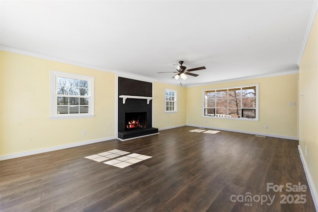 unfurnished living room with dark wood finished floors, a brick fireplace, crown molding, and baseboards