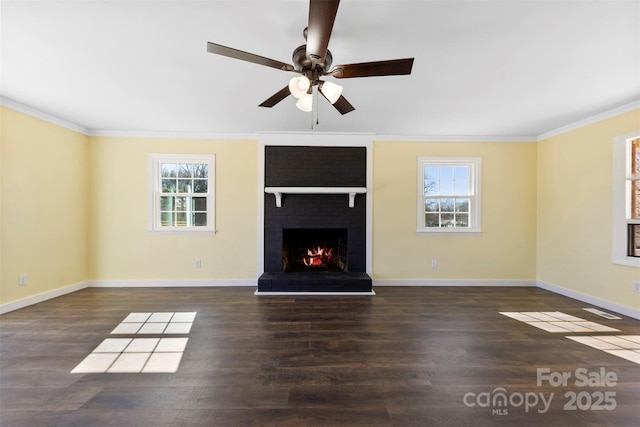 unfurnished living room featuring crown molding, a fireplace, a wealth of natural light, and wood finished floors