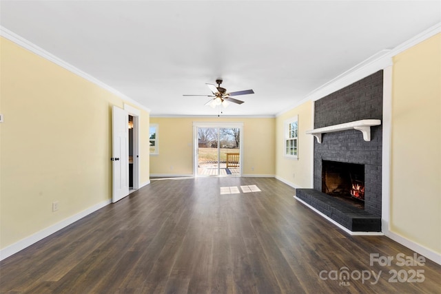 unfurnished living room featuring ornamental molding, dark wood-style flooring, a brick fireplace, and baseboards