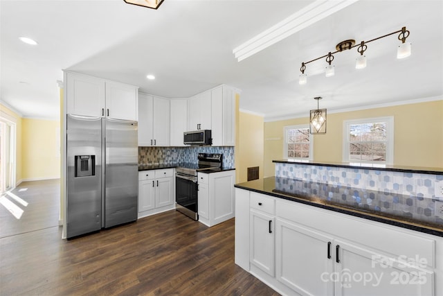 kitchen featuring white cabinets, appliances with stainless steel finishes, dark wood-style floors, dark countertops, and crown molding