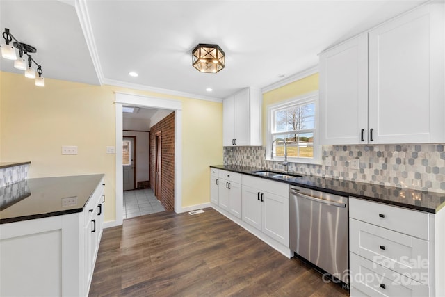 kitchen with decorative backsplash, dishwasher, dark countertops, ornamental molding, and a sink