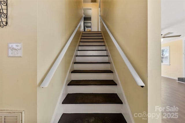 stairway featuring visible vents and a ceiling fan