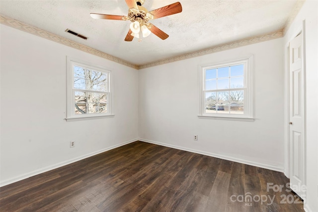 unfurnished bedroom with baseboards, visible vents, dark wood finished floors, and a textured ceiling