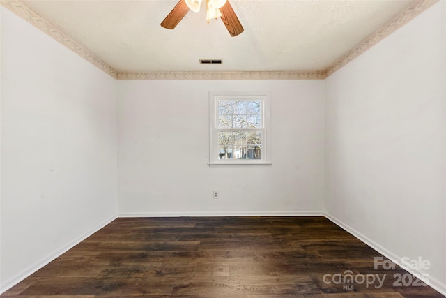 spare room featuring a ceiling fan, wood finished floors, visible vents, and baseboards