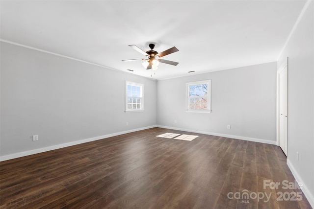 spare room with ceiling fan, dark wood finished floors, visible vents, and baseboards